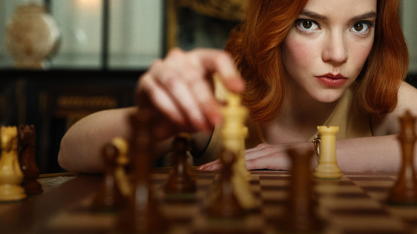 Beth Harmon looking over chess board into camera, finger on the king; Credit: Lifestyle Asia
