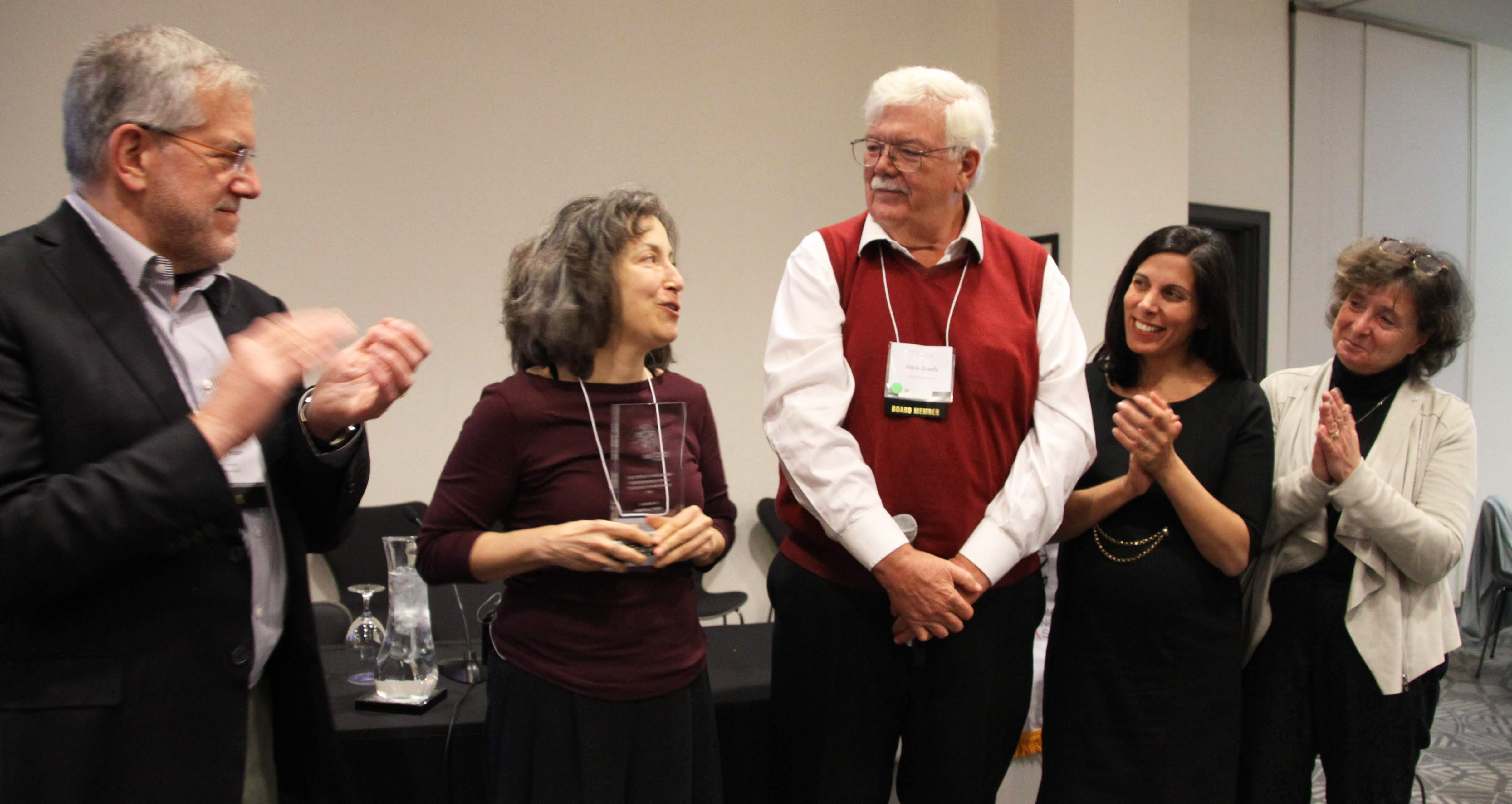 Photo of Steve Hyman, Martha Farah accepting an award plaque, Hank Greely, Nita Farahany and Judy Illes