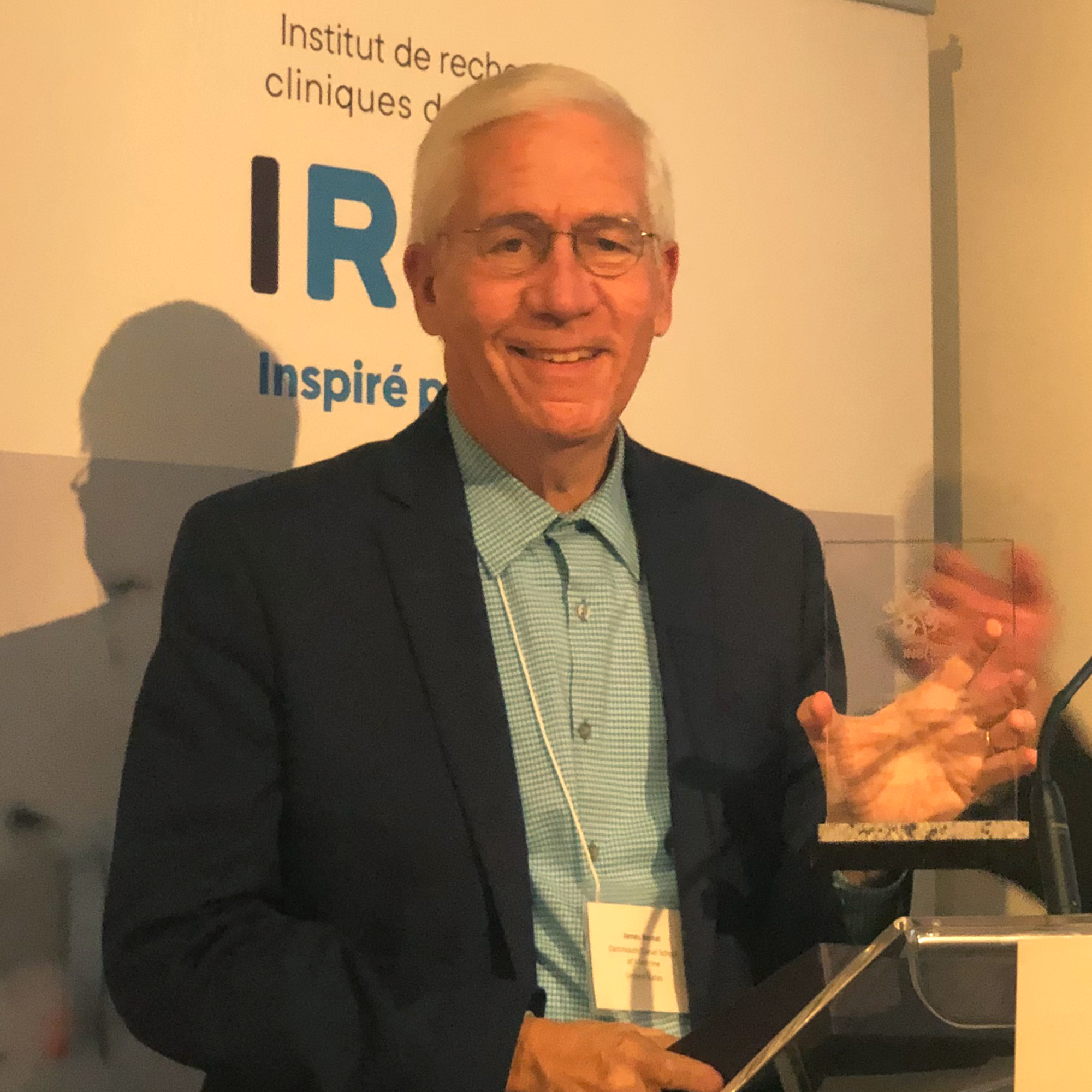 Dr. James Bernat holding a glass award at the 2022 INS Annual Meeting in Montreal, Canada; Credit: Roland Nadler;
