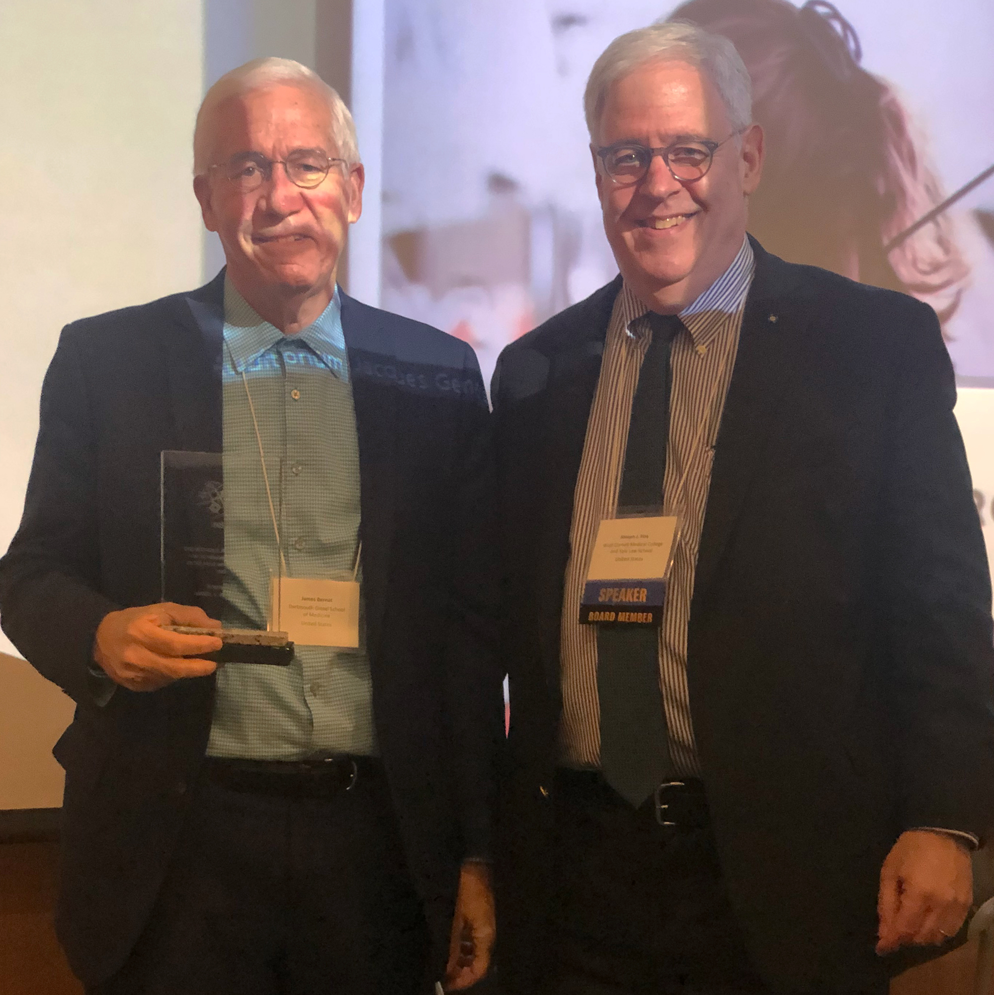 Dr. James Bernat holding an award and Joseph J. Fins posing for a photo 2022 INS Annual Meeting in Montreal, Canada;